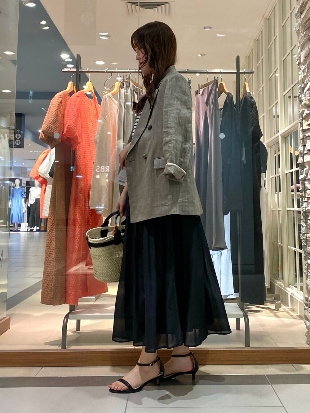 グレー系のテーラードジャケット、ピンク系のTシャツ/カットソー、ブラック系のかごバッグを着用したレディースの春コーディネートの5枚目の写真