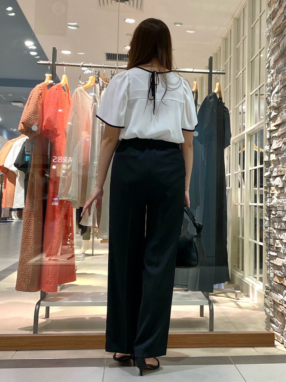 ベージュ系のその他パンツ、ブラック系のショルダーバッグ、ホワイト系のシャツ/ブラウスを着用したレディースの春コーディネートの4枚目の写真