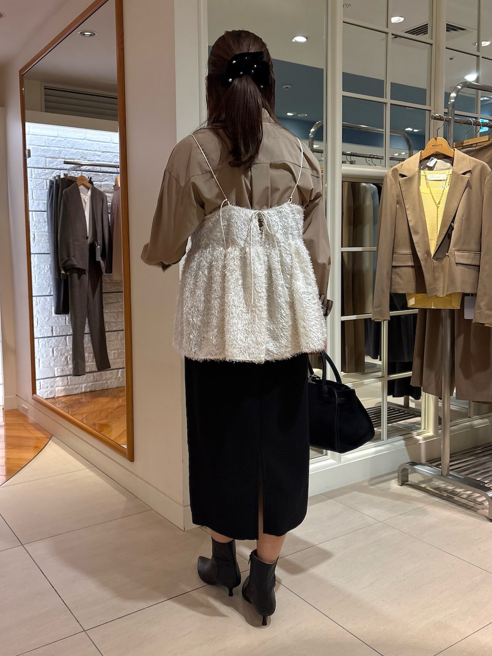 ホワイト系のキャミソール、ブルー系のシャツ/ブラウス、ブラック系のスカートを着用したレディースの冬コーディネートの5枚目の写真