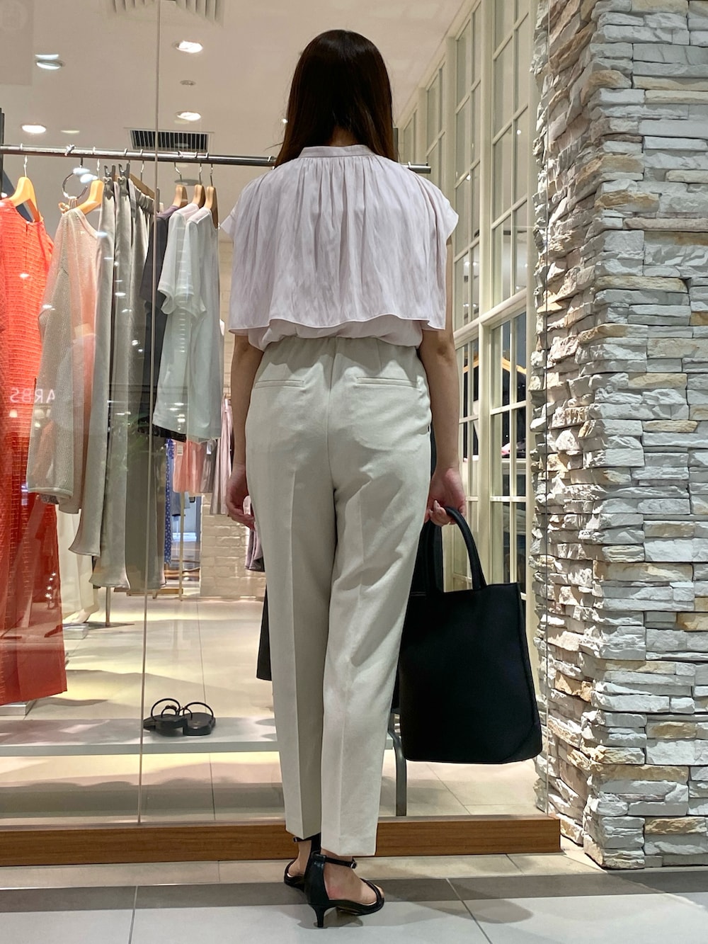 ブラック系のトートバッグ、シルバー系のサンダル、ベージュ系のその他パンツを着用したレディースの春コーディネートの3枚目の写真