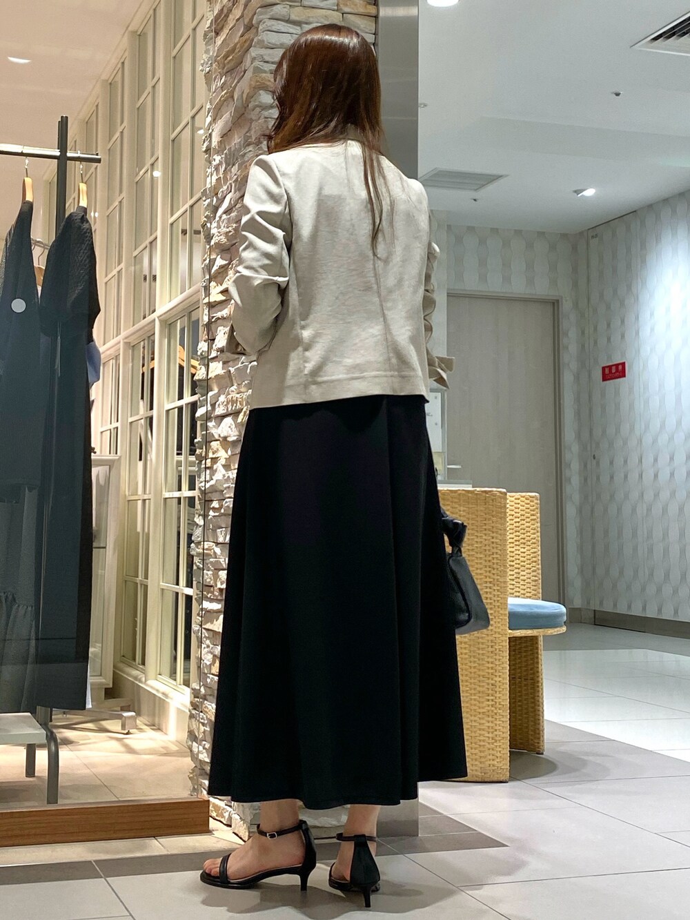 ブラック系のショルダーバッグ、シルバー系のサンダル、ベージュ系のテーラードジャケットを着用したレディースの春コーディネートの4枚目の写真