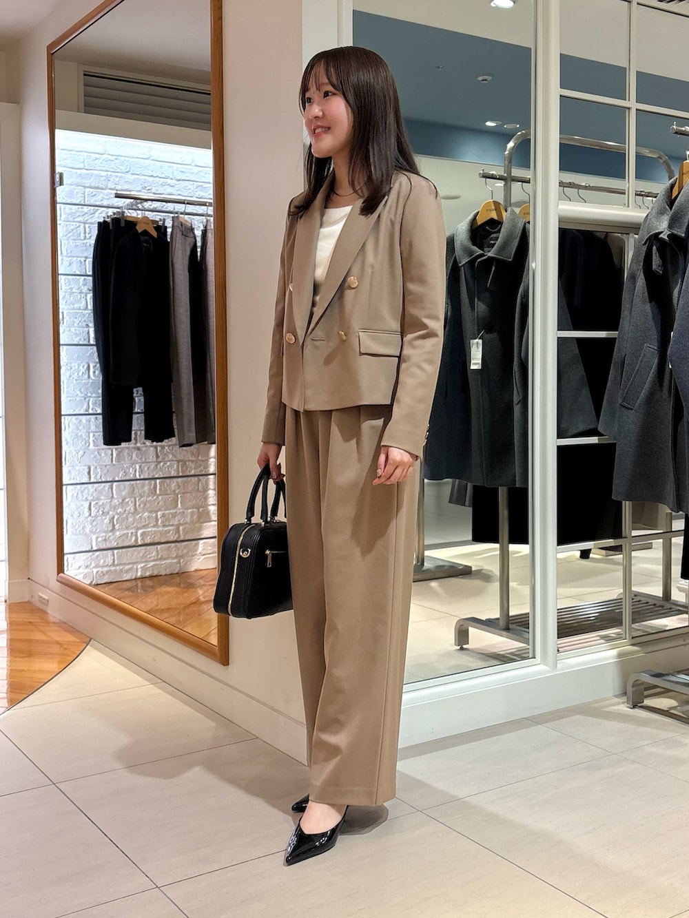 イエロー系のその他パンツ、イエロー系のテーラードジャケット、ブラック系のボストンバッグを着用したレディースの秋コーディネートの3枚目の写真