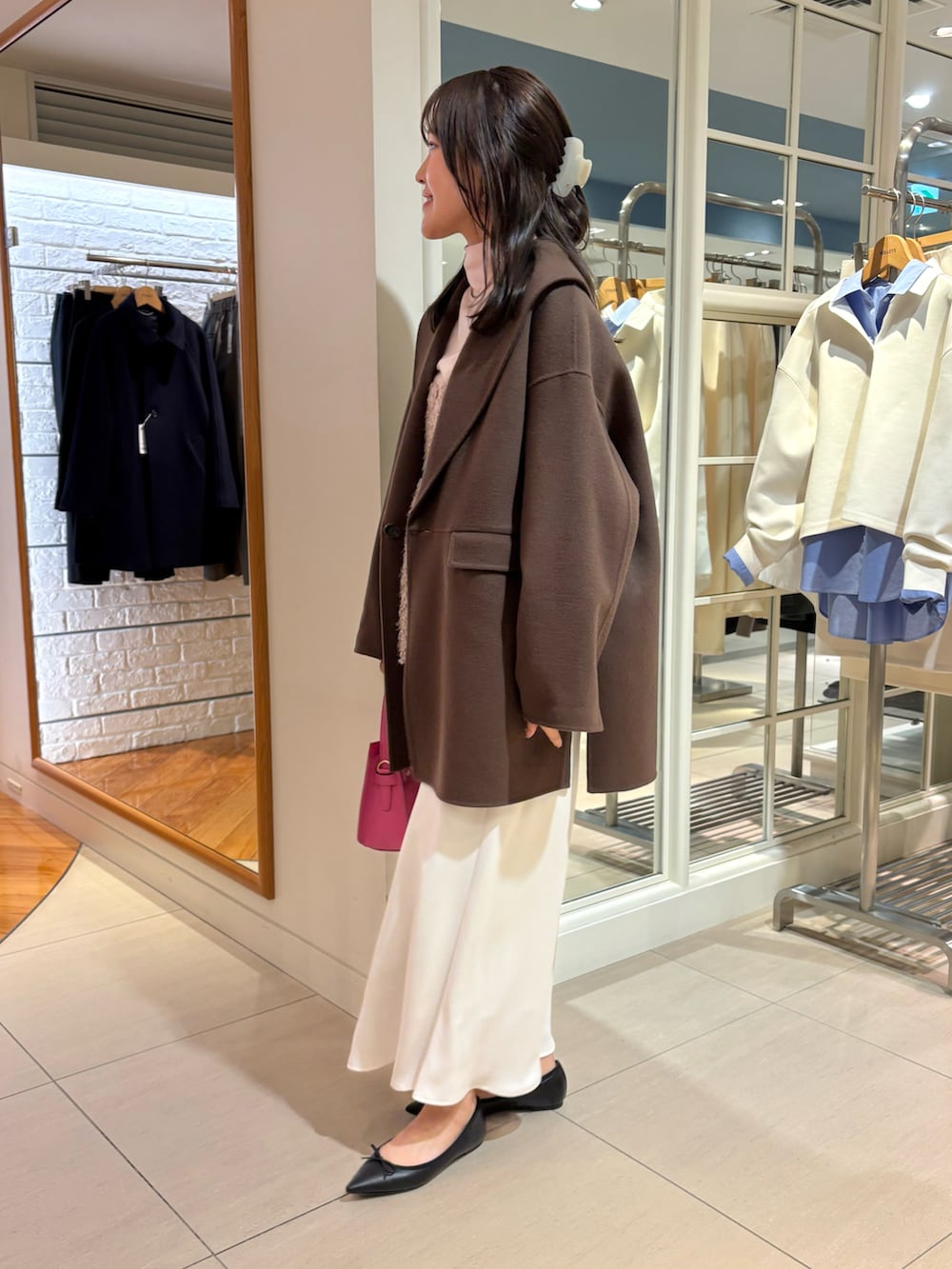 ベージュ系のキャミソール、ピンク系のニット/セーター、ホワイト系のスカートを着用したレディースの秋コーディネートの3枚目の写真