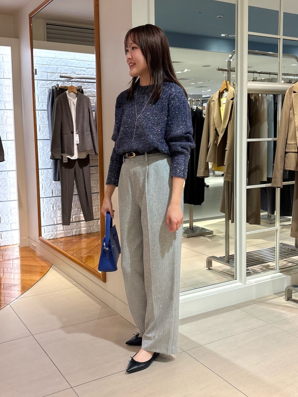 グレー系のその他パンツ、ブルー系のニット/セーター、ブルー系のショルダーバッグを着用したレディースの冬コーディネートの6枚目の写真