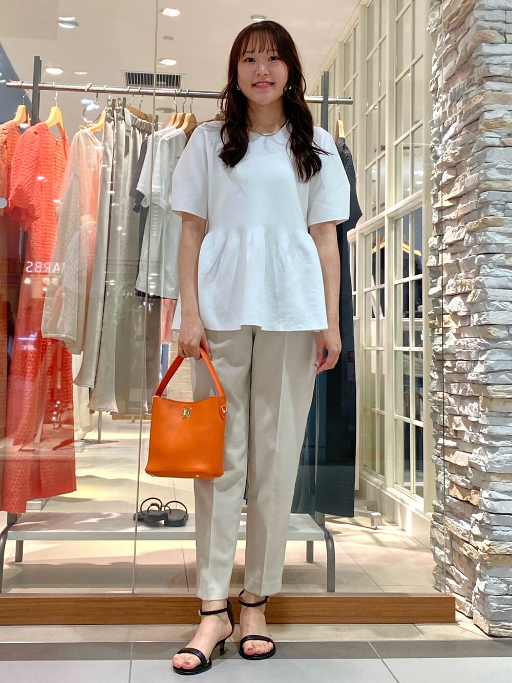 ベージュ系のその他パンツ、ホワイト系のニット/セーター、ホワイト系のショルダーバッグを着用したレディースの春コーディネートの5枚目の写真