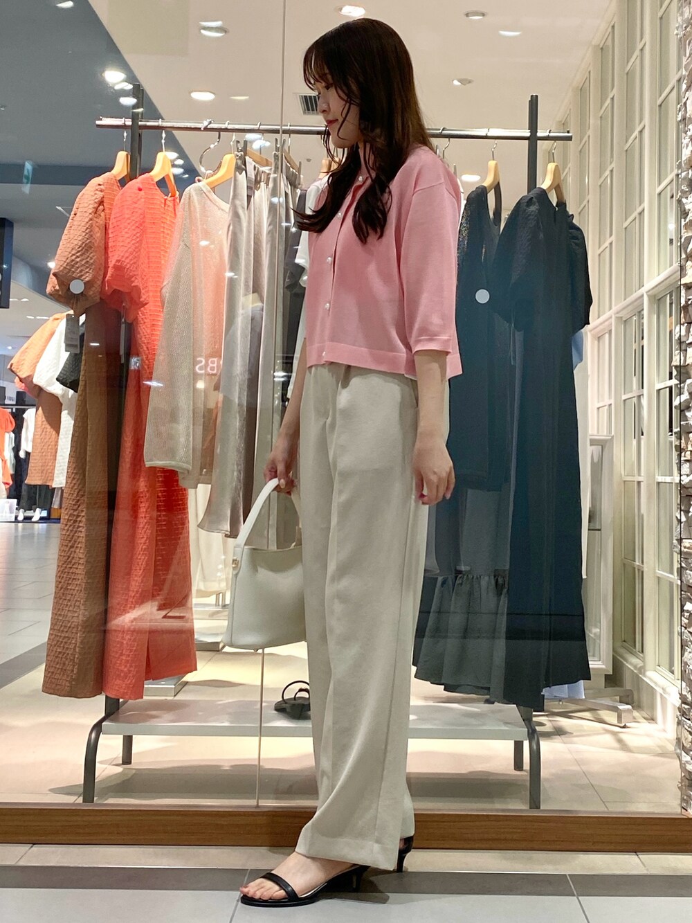 イエロー系のその他パンツ、ピンク系のカーディガン/ボレロ、ピンク系のニット/セーターを着用したレディースの春コーディネートの2枚目の写真