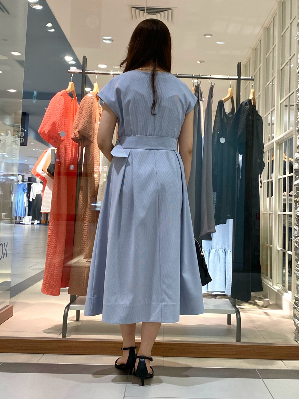 ブラック系のボストンバッグ、ブルー系のワンピース、シルバー系のサンダルを着用したレディースの春コーディネートの4枚目の写真