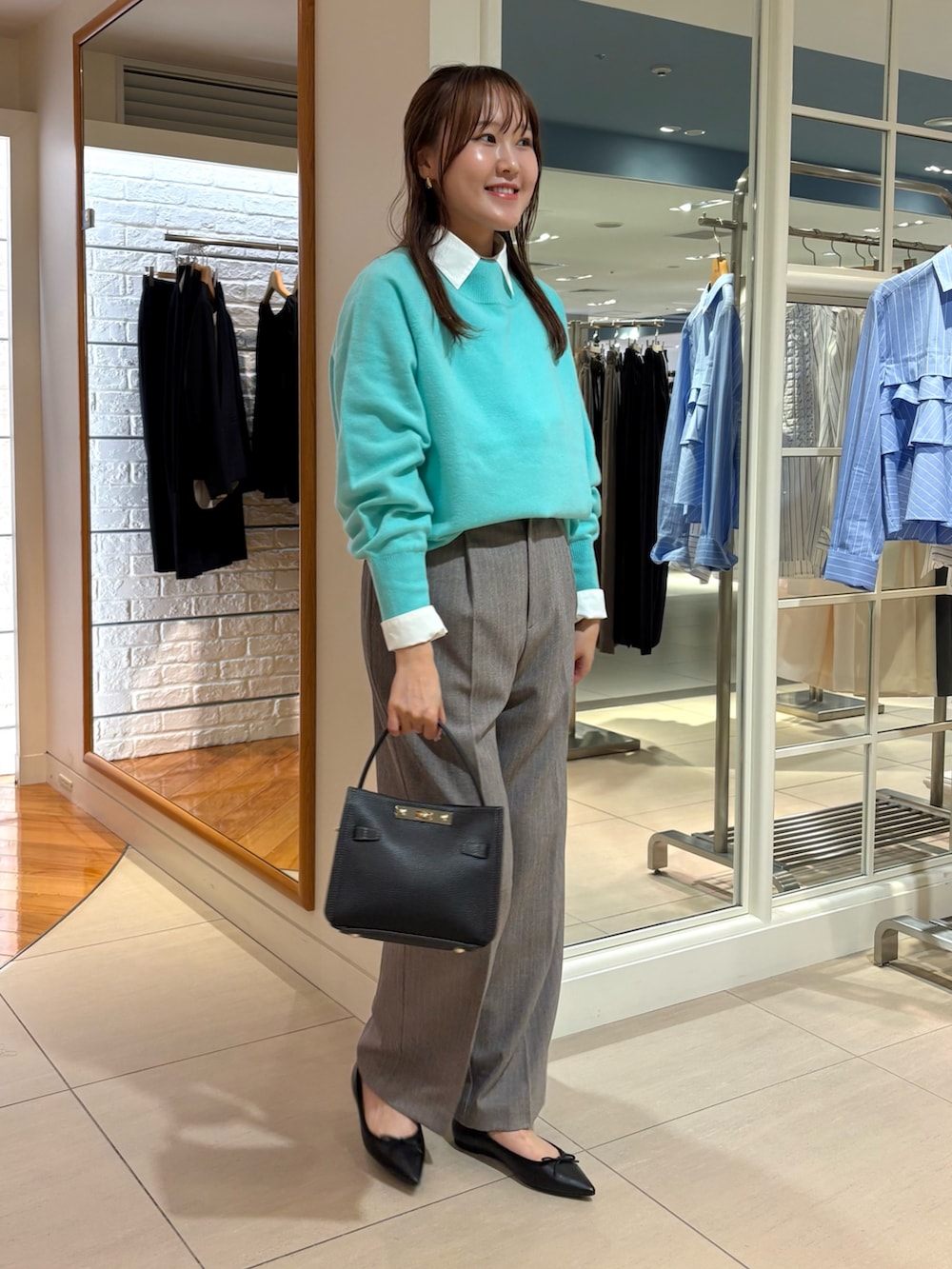 グレー系のその他パンツ、ベージュ系のショルダーバッグ、ピンク系のニット/セーターを着用したレディースの秋コーディネートの2枚目の写真