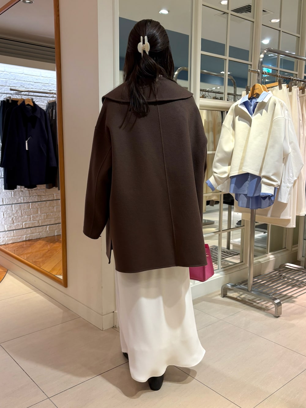 ベージュ系のキャミソール、ピンク系のニット/セーター、ホワイト系のスカートを着用したレディースの秋コーディネートの4枚目の写真