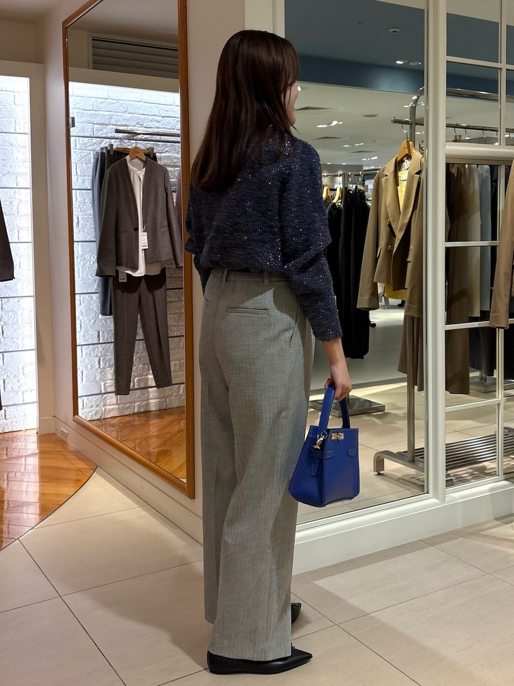 グレー系のその他パンツ、ブルー系のニット/セーター、ブルー系のショルダーバッグを着用したレディースの冬コーディネートの2枚目の写真