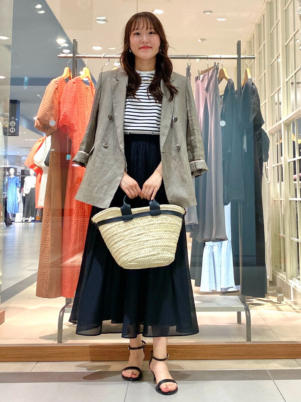 グレー系のテーラードジャケット、ピンク系のTシャツ/カットソー、ブラック系のかごバッグを着用したレディースの春コーディネートの2枚目の写真