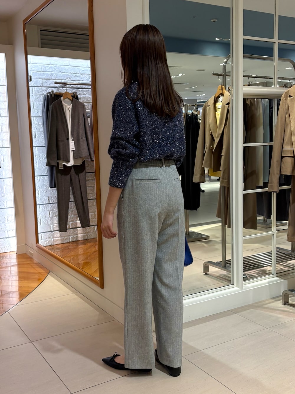 グレー系のその他パンツ、ブルー系のニット/セーター、ブルー系のショルダーバッグを着用したレディースの冬コーディネートの4枚目の写真