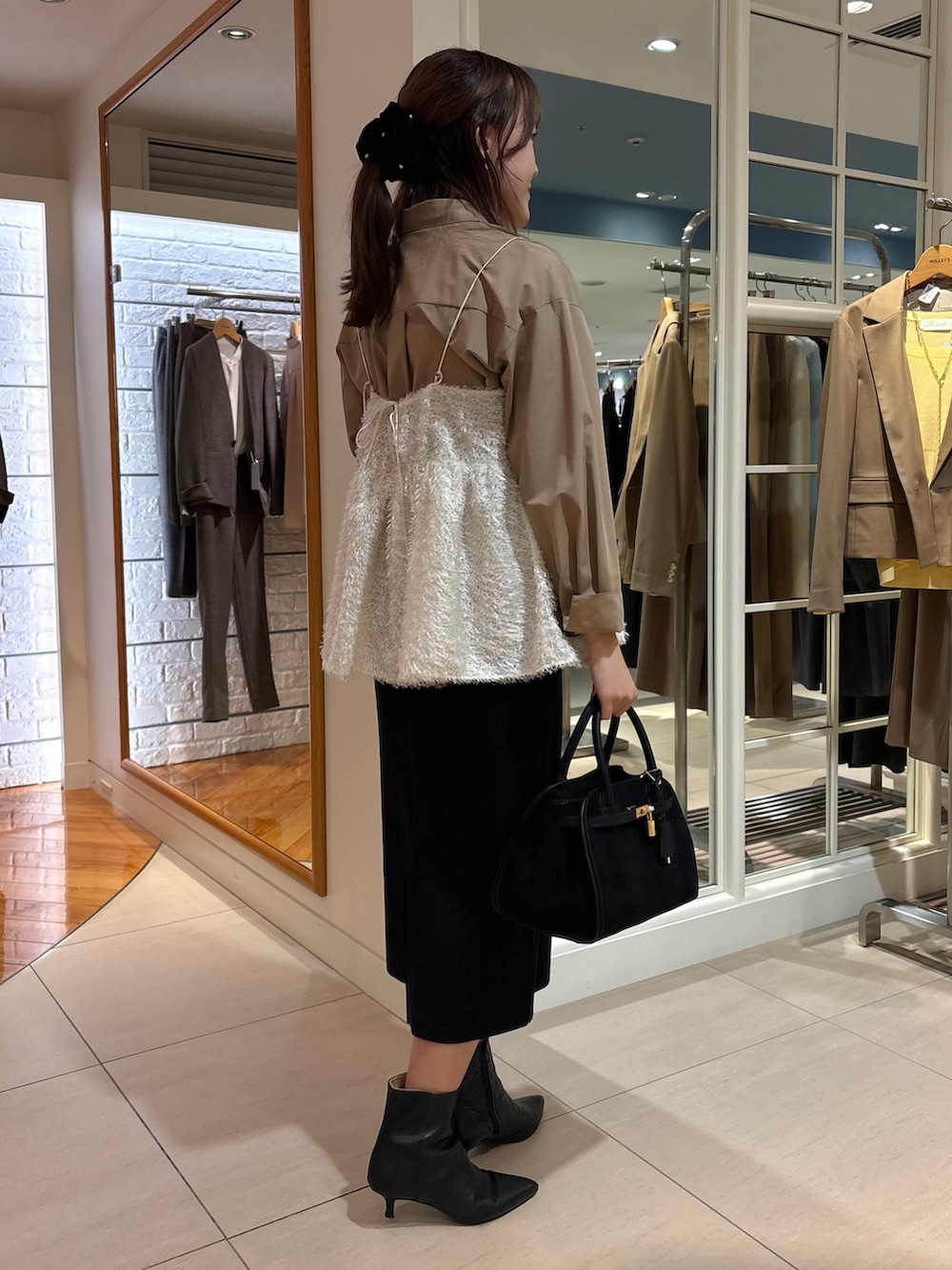 ホワイト系のキャミソール、ブルー系のシャツ/ブラウス、ブラック系のスカートを着用したレディースの冬コーディネートの6枚目の写真