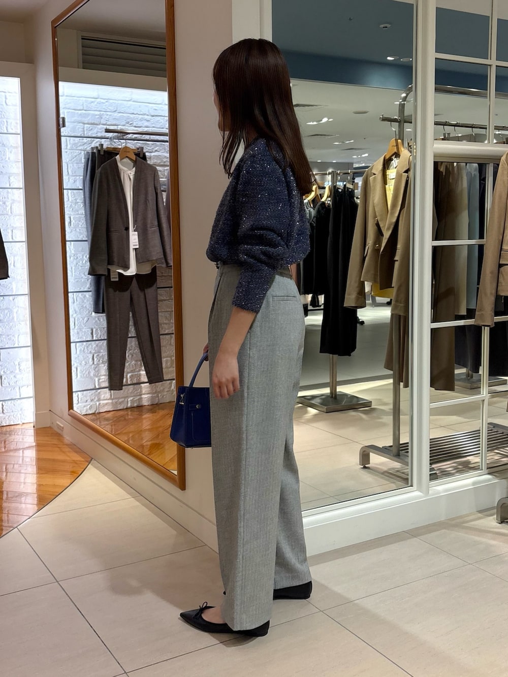 グレー系のその他パンツ、ブルー系のニット/セーター、ブルー系のショルダーバッグを着用したレディースの冬コーディネートの5枚目の写真