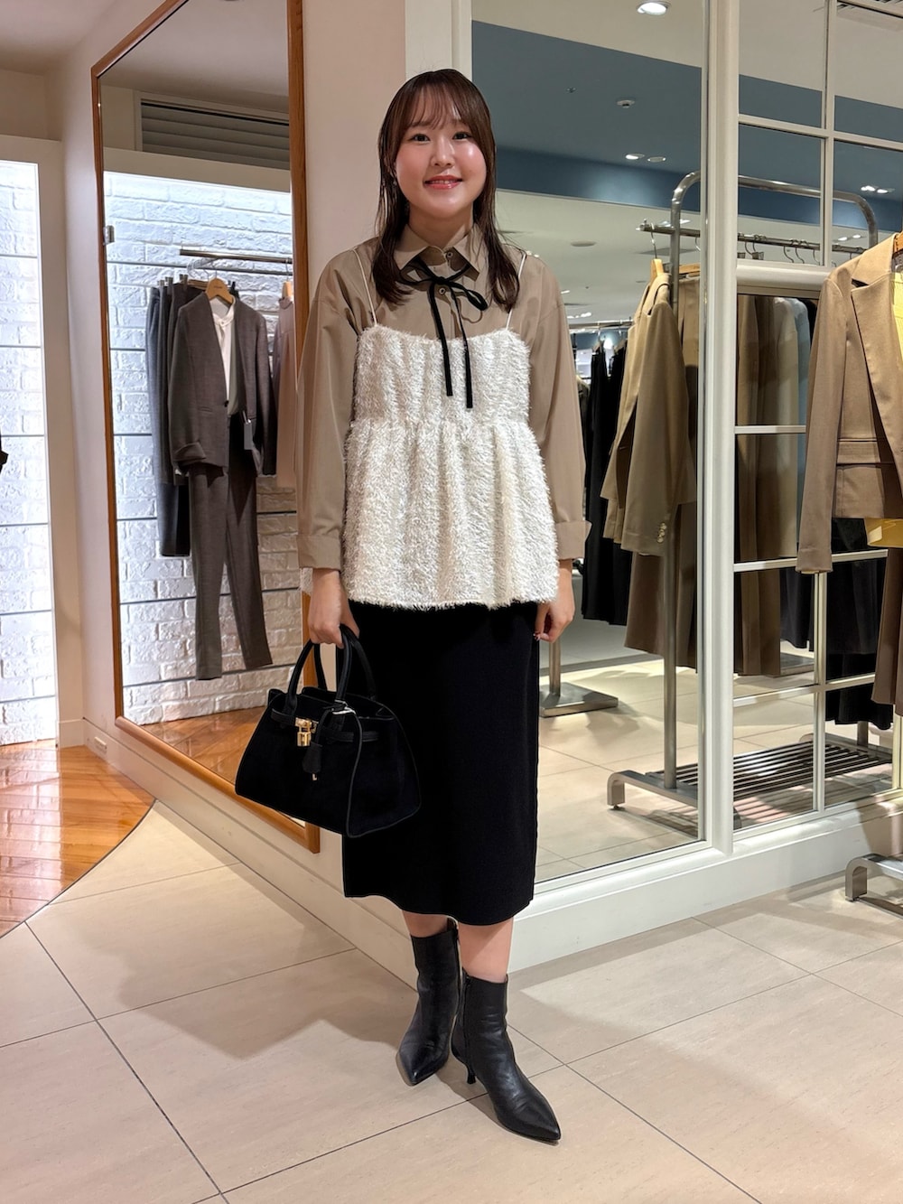 ホワイト系のキャミソール、ブルー系のシャツ/ブラウス、ブラック系のスカートを着用したレディースの冬コーディネートの8枚目の写真