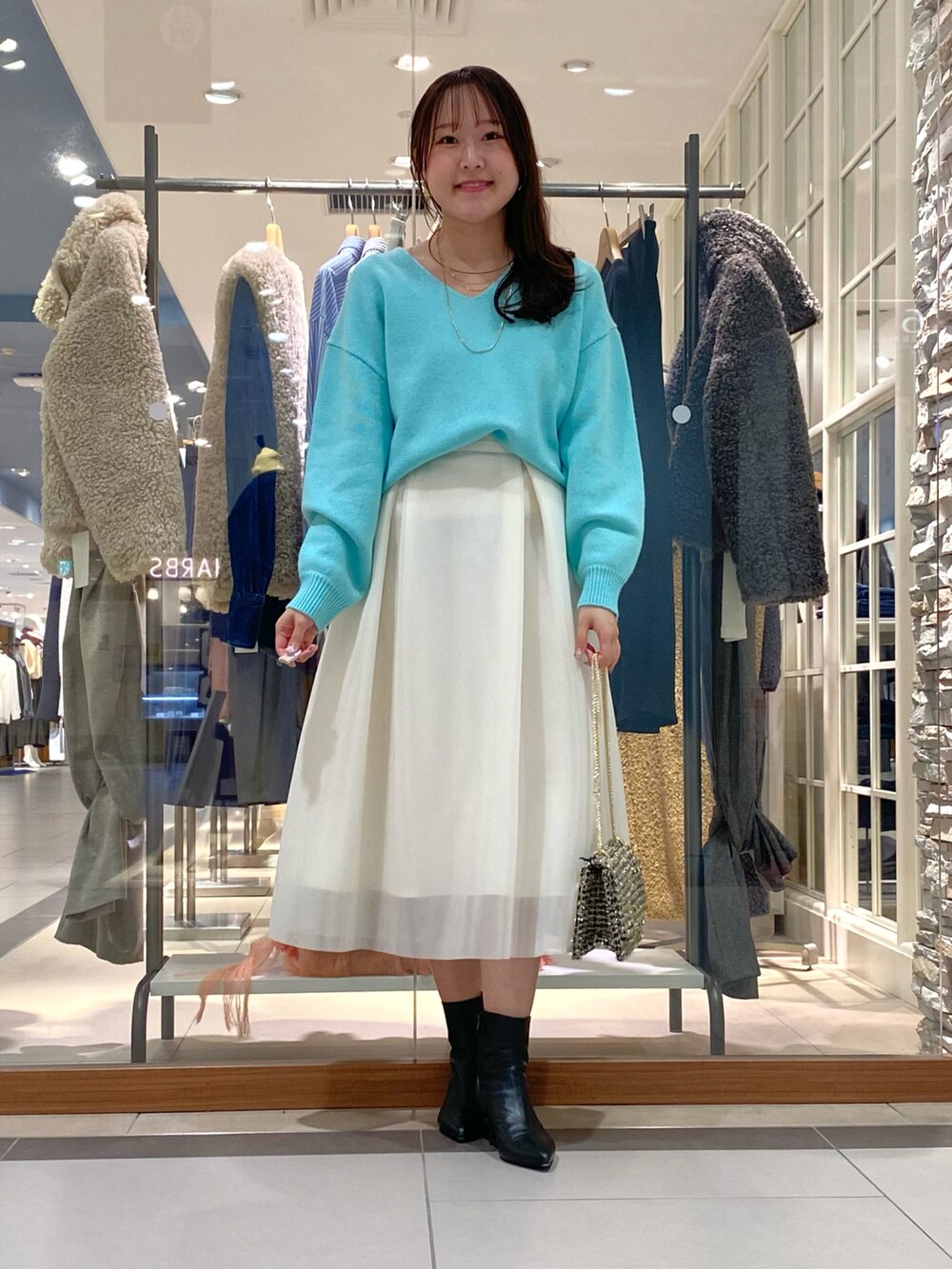 ホワイト系のスカート、グリーン系のニット/セーター、その他のショルダーバッグを着用したレディースの冬コーディネートの4枚目の写真