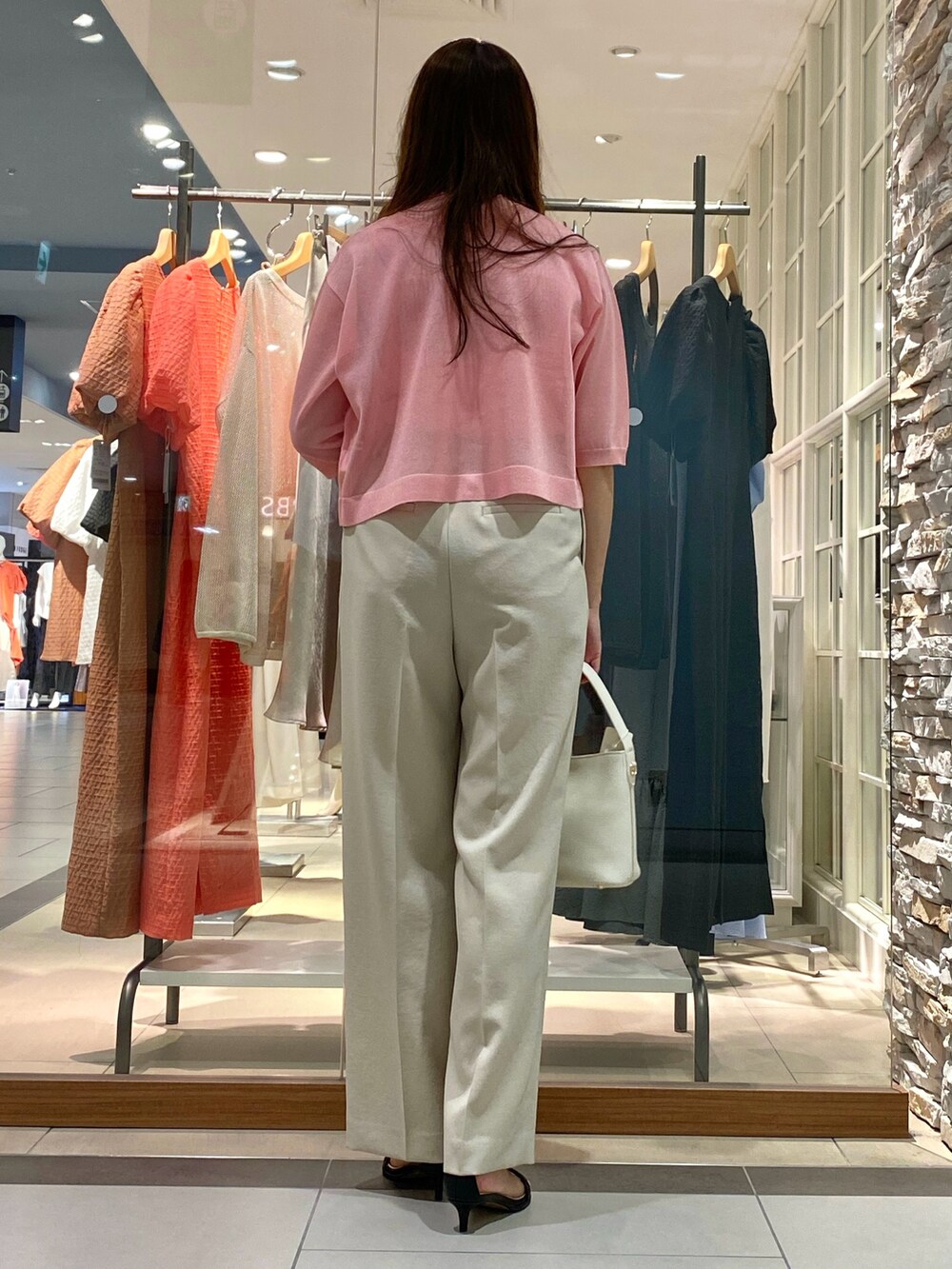 イエロー系のその他パンツ、ピンク系のカーディガン/ボレロ、ピンク系のニット/セーターを着用したレディースの春コーディネートの3枚目の写真