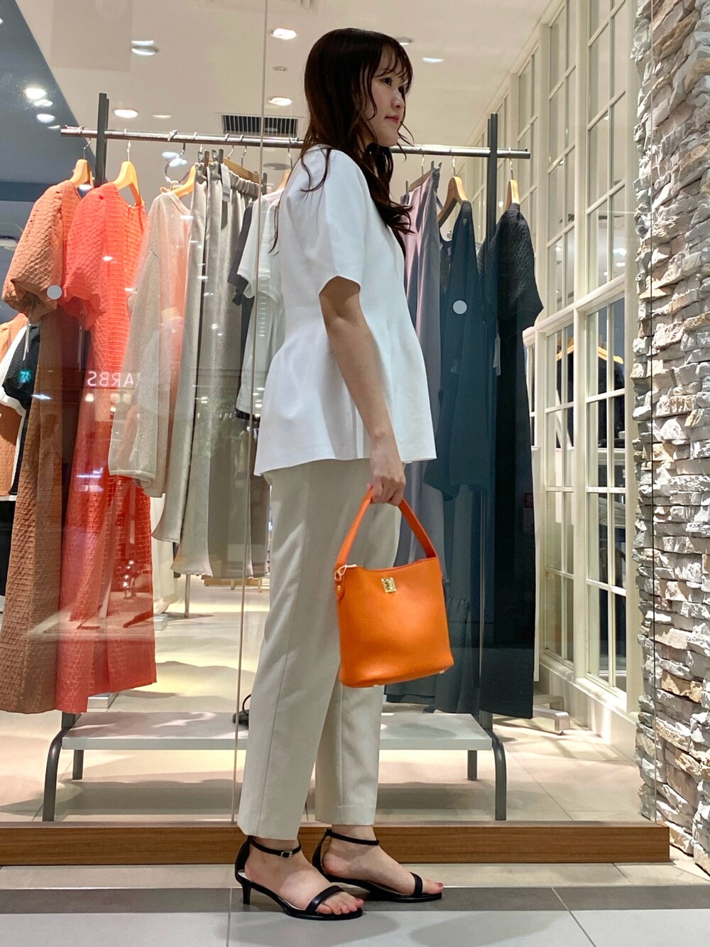 ベージュ系のその他パンツ、ホワイト系のニット/セーター、ホワイト系のショルダーバッグを着用したレディースの春コーディネートの4枚目の写真