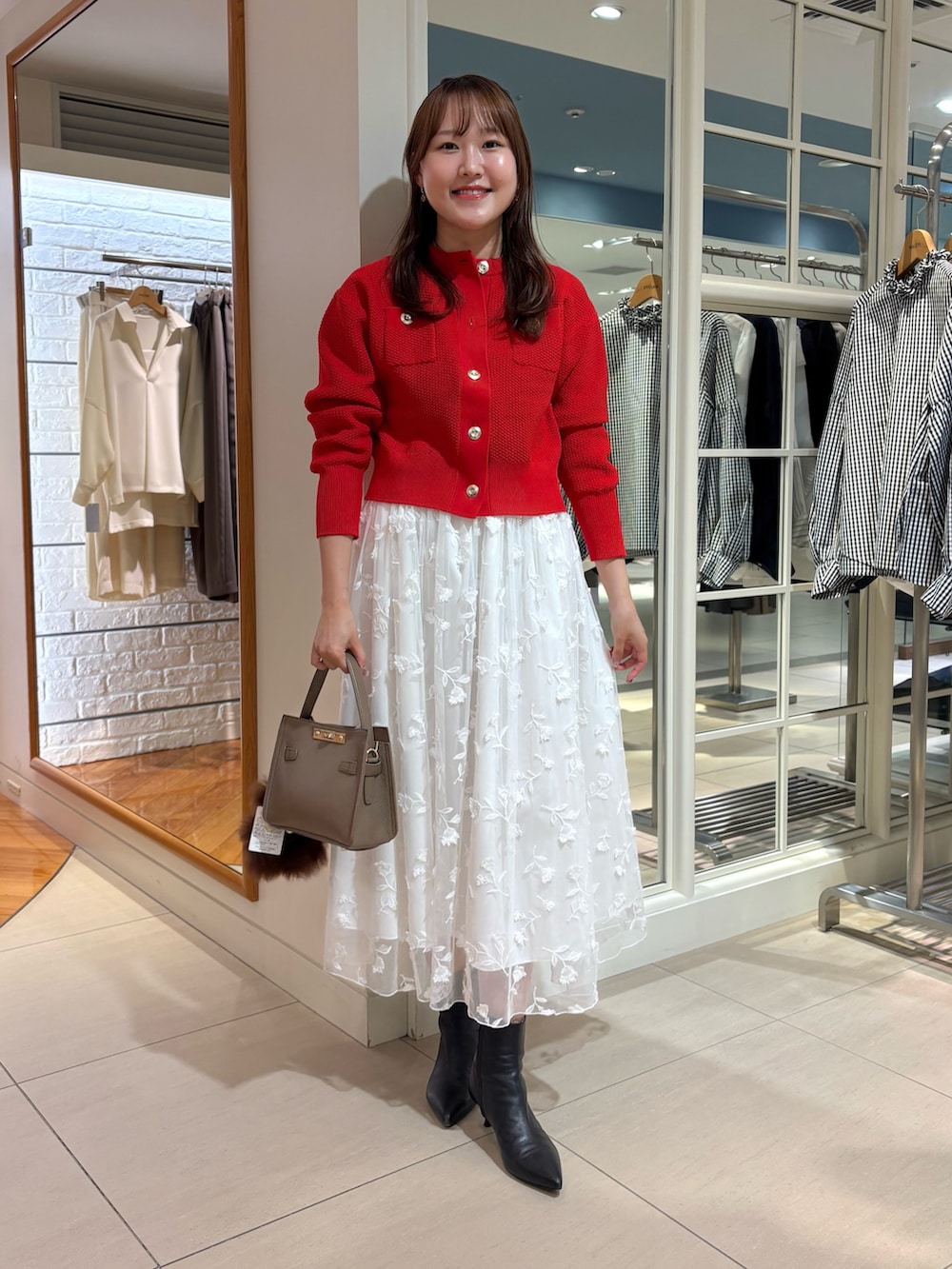 ホワイト系のスカート、レッド系のカーディガン/ボレロ、ベージュ系のショルダーバッグを着用したレディースの秋コーディネートの9枚目の写真