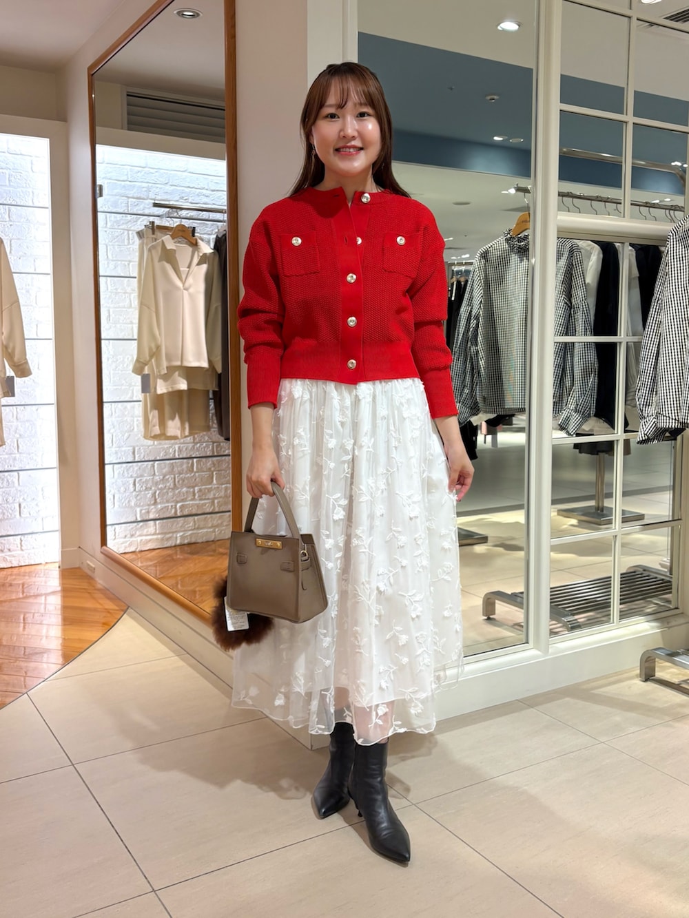 ホワイト系のスカート、レッド系のカーディガン/ボレロ、ベージュ系のショルダーバッグを着用したレディースの秋コーディネートの8枚目の写真