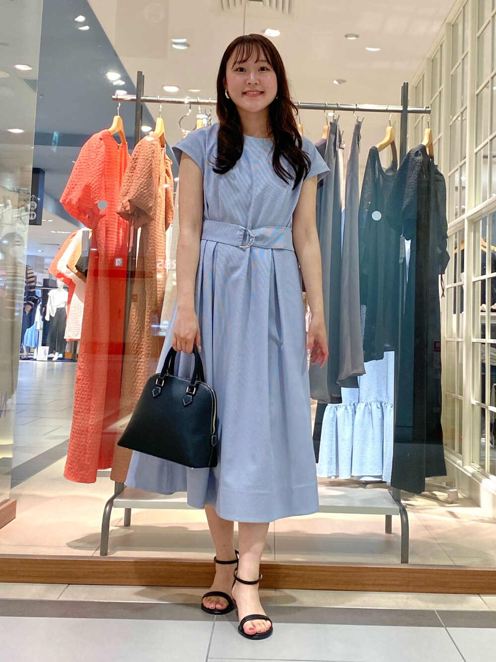 ブラック系のボストンバッグ、ブルー系のワンピース、シルバー系のサンダルを着用したレディースの春コーディネートの2枚目の写真