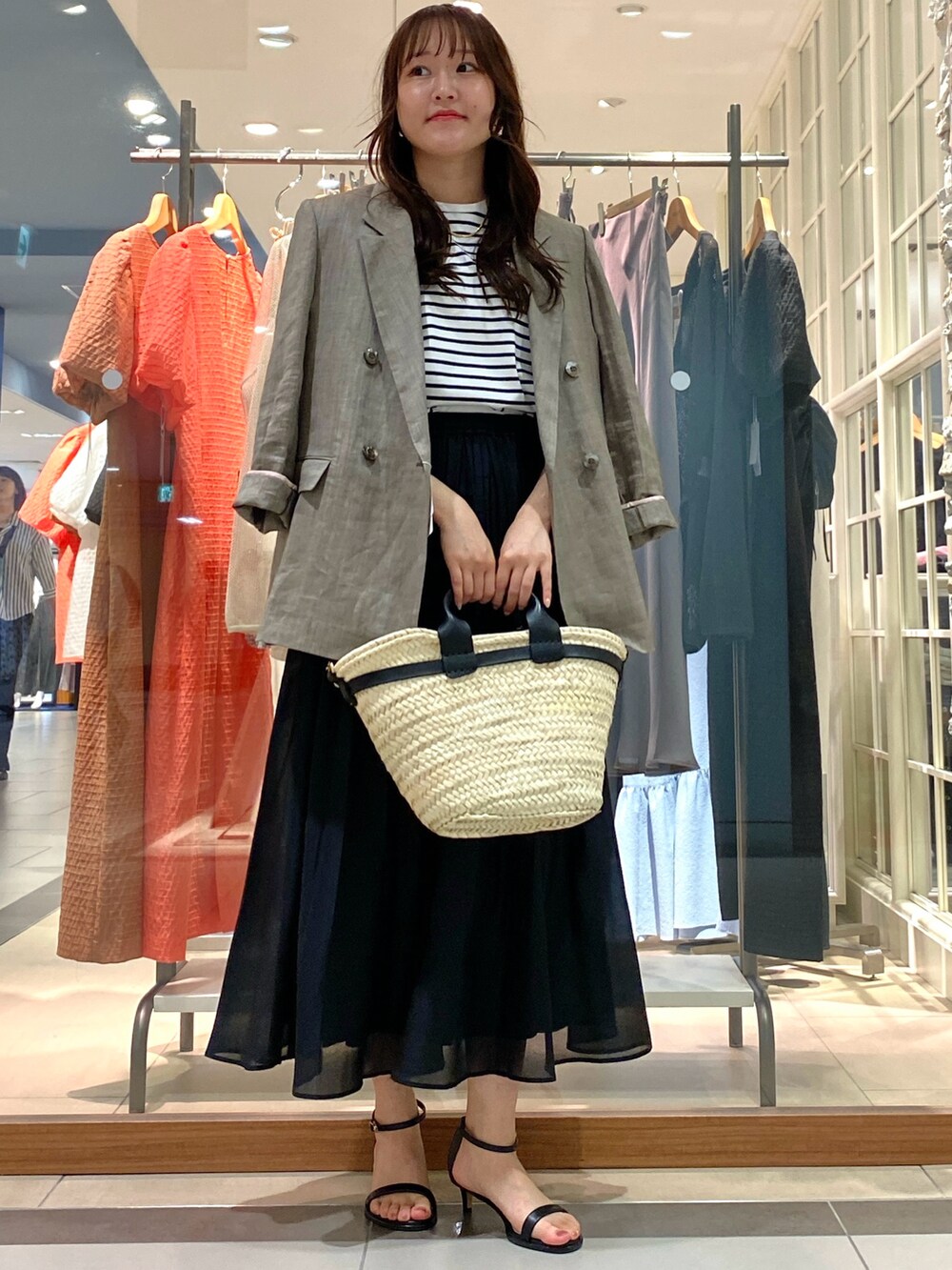 グレー系のテーラードジャケット、ピンク系のTシャツ/カットソー、ブラック系のかごバッグを着用したレディースの春コーディネートの3枚目の写真