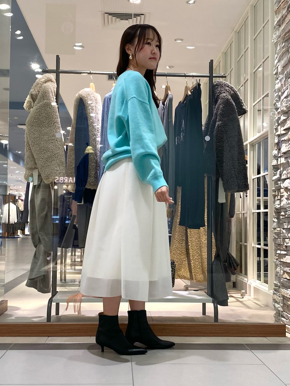 ホワイト系のスカート、グリーン系のニット/セーター、その他のショルダーバッグを着用したレディースの冬コーディネートの3枚目の写真