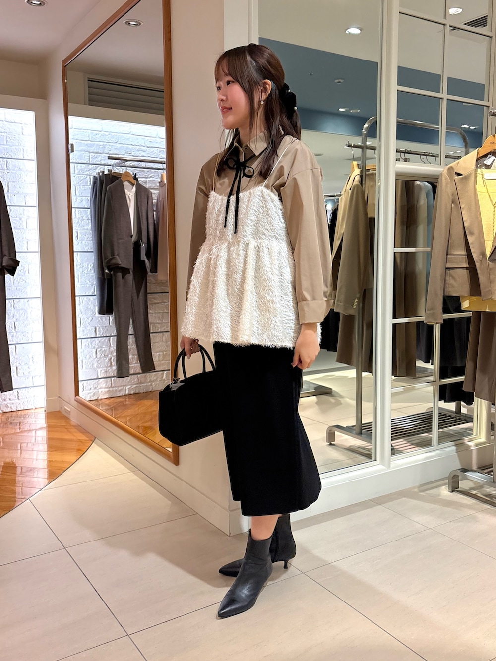 ホワイト系のキャミソール、ブルー系のシャツ/ブラウス、ブラック系のスカートを着用したレディースの冬コーディネートの3枚目の写真