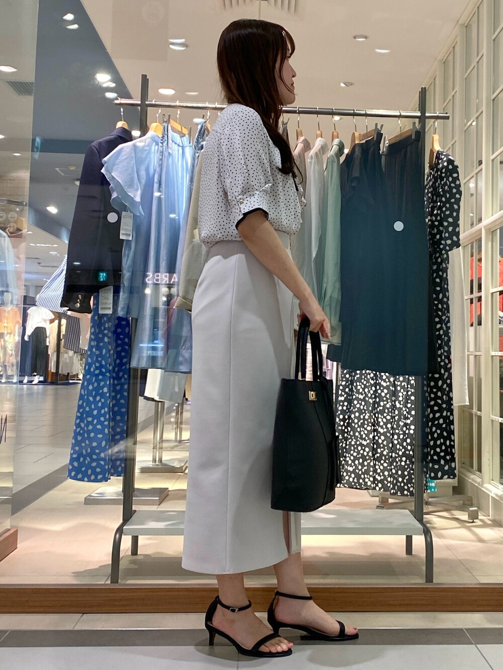 ホワイト系のシャツ/ブラウス、ホワイト系のスカート、ブラック系のトートバッグを着用したレディースの夏コーディネートの4枚目の写真