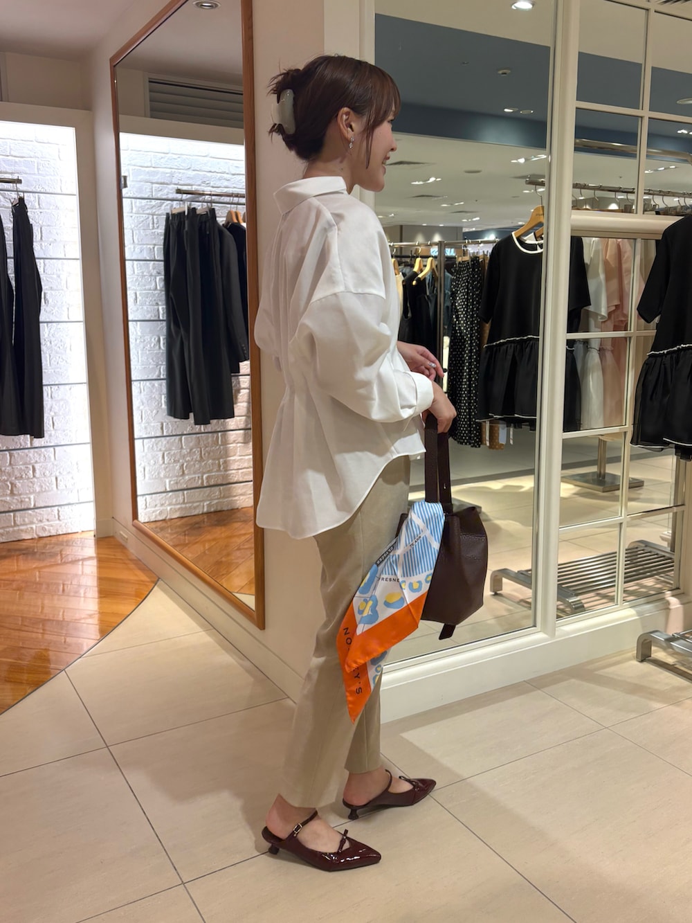 ブラウン系のショルダーバッグ、ホワイト系のシャツ/ブラウス、ベージュ系のその他パンツを着用したレディースの秋コーディネートの4枚目の写真