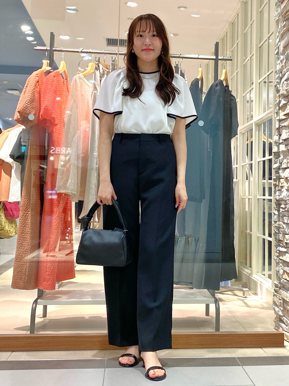 ベージュ系のその他パンツ、ブラック系のショルダーバッグ、ホワイト系のシャツ/ブラウスを着用したレディースの春コーディネートの2枚目の写真