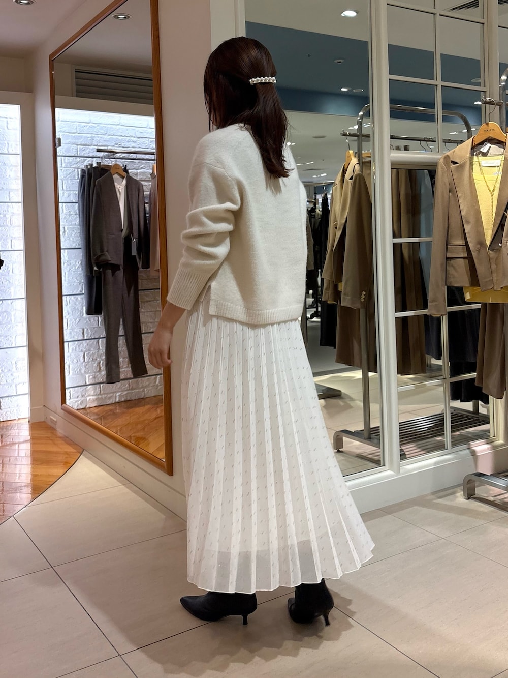 ホワイト系のスカート、ベージュ系のショルダーバッグ、ブルー系のニット/セーターを着用したレディースの冬コーディネートの5枚目の写真