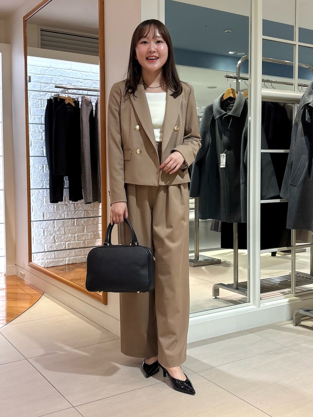 イエロー系のその他パンツ、イエロー系のテーラードジャケット、ブラック系のボストンバッグを着用したレディースの秋コーディネートの2枚目の写真