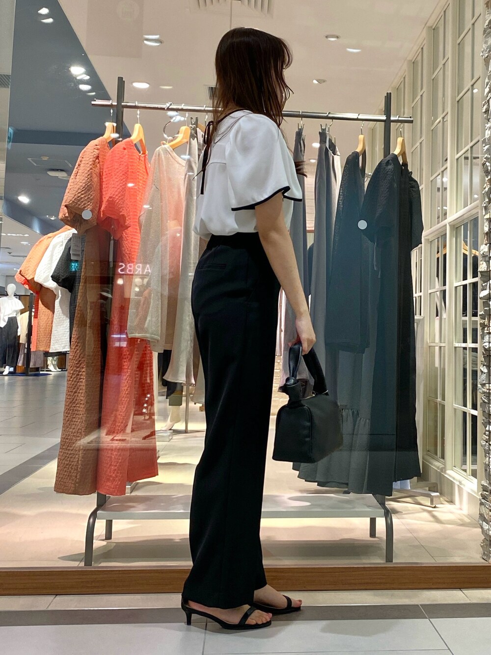 ベージュ系のその他パンツ、ブラック系のショルダーバッグ、ホワイト系のシャツ/ブラウスを着用したレディースの春コーディネートの3枚目の写真