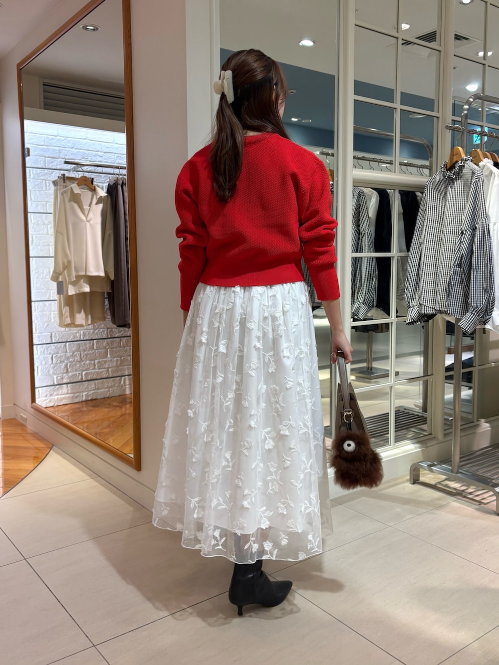 ホワイト系のスカート、レッド系のカーディガン/ボレロ、ベージュ系のショルダーバッグを着用したレディースの秋コーディネートの4枚目の写真