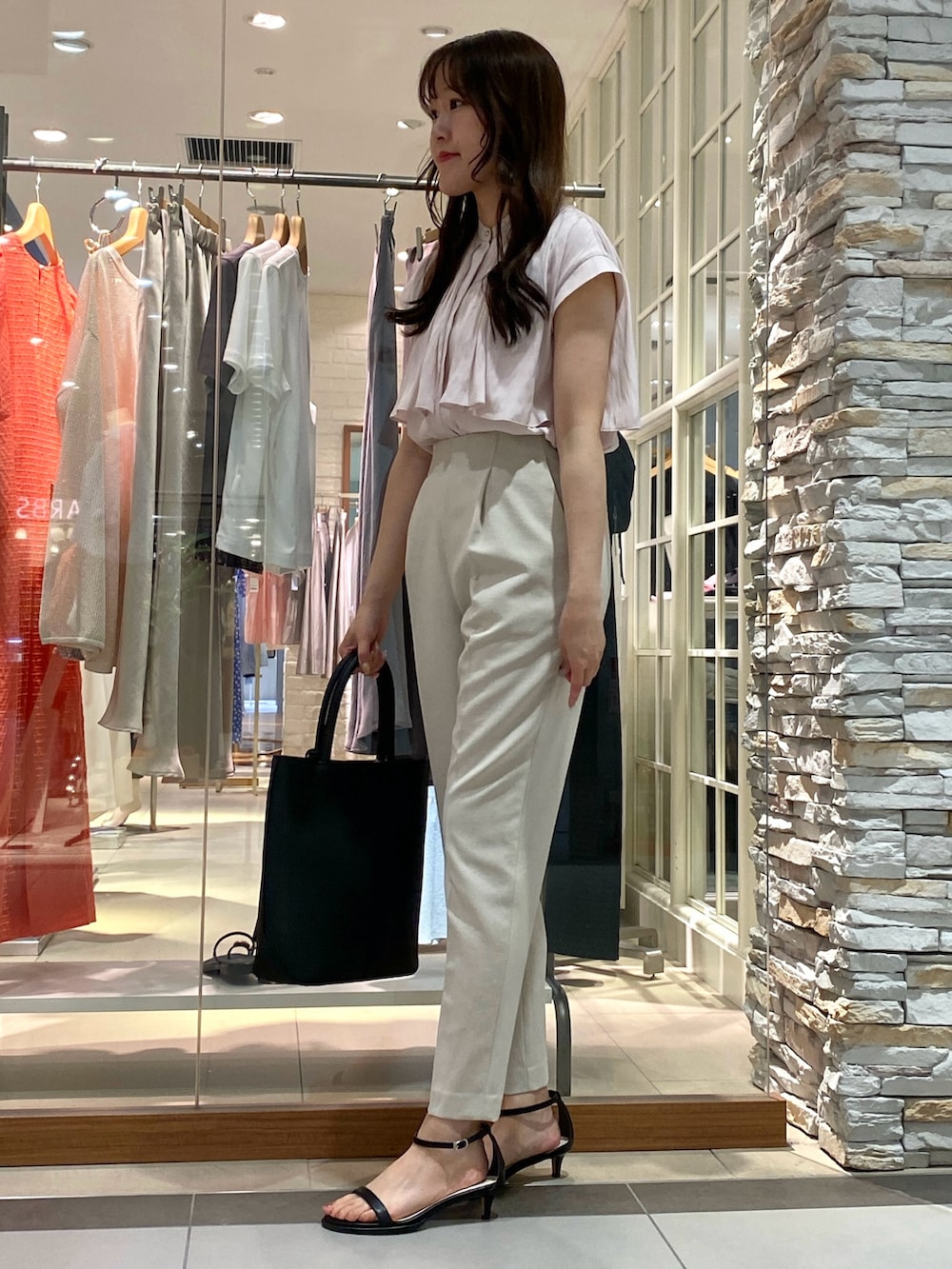 ブラック系のトートバッグ、シルバー系のサンダル、ベージュ系のその他パンツを着用したレディースの春コーディネートの4枚目の写真