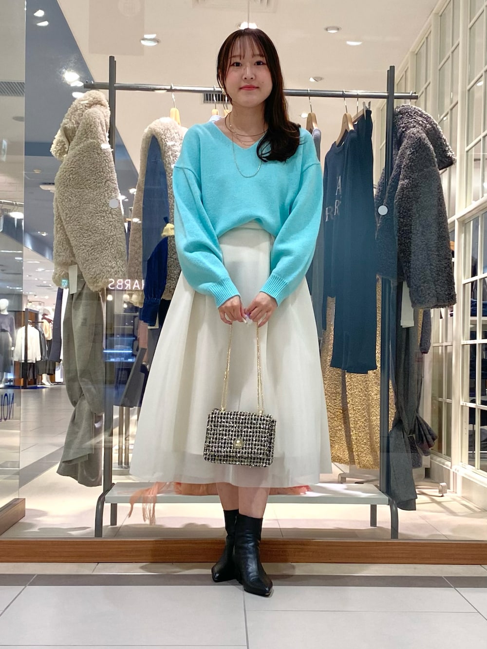 ホワイト系のスカート、グリーン系のニット/セーター、その他のショルダーバッグを着用したレディースの冬コーディネートの5枚目の写真