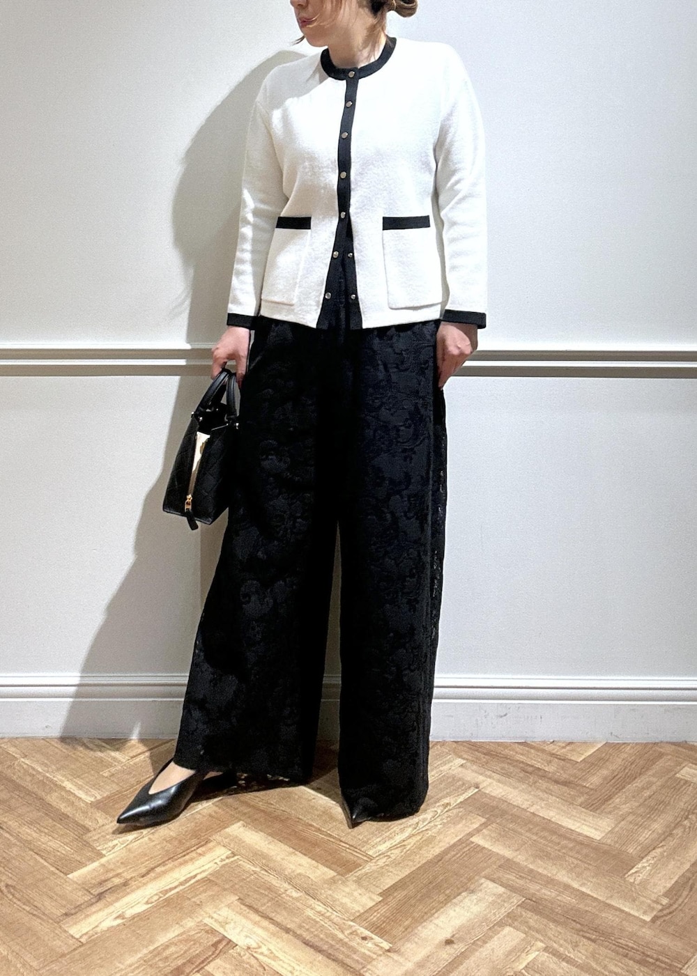 ブラック系のハンドバッグ、ブラック系のパンプス、ブラック系のその他パンツを着用したレディースの秋コーディネートの2枚目の写真