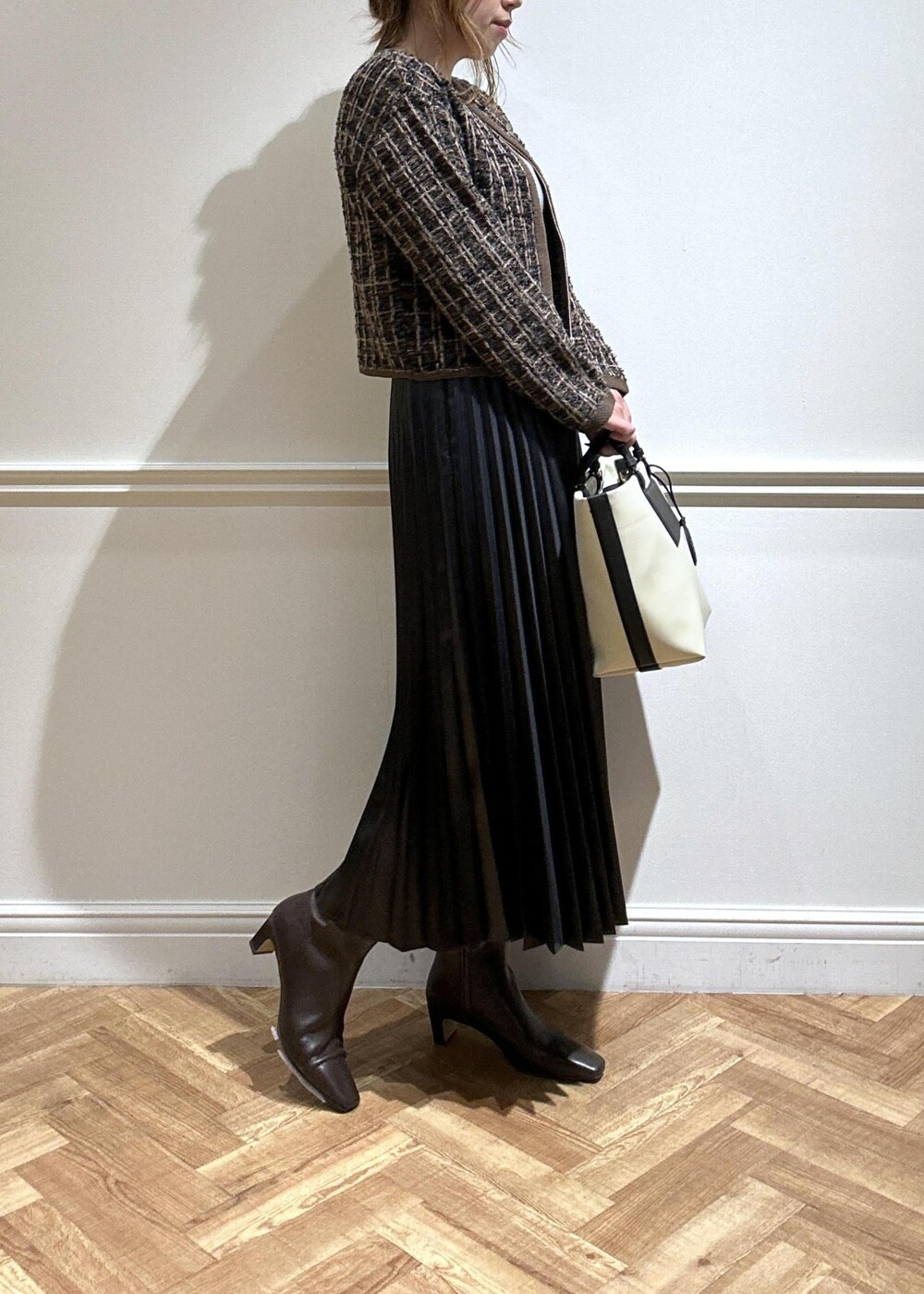 ブラウン系のブーツ、ブラック系のスカート、グレー系のニット/セーターを着用したレディースの秋コーディネートの4枚目の写真