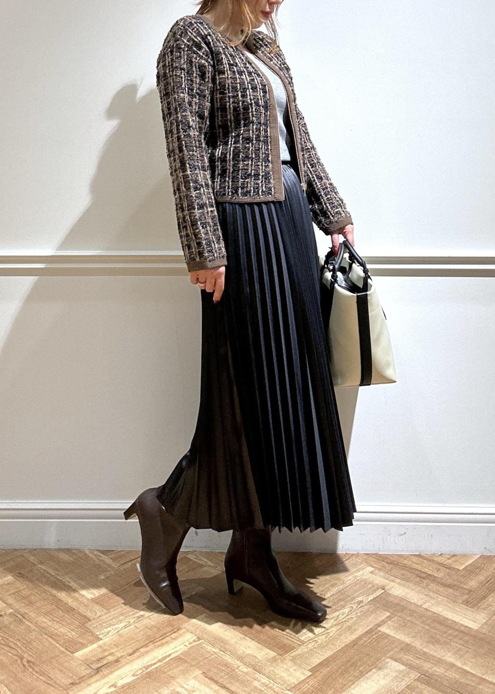 ブラウン系のブーツ、ブラック系のスカート、グレー系のニット/セーターを着用したレディースの秋コーディネートの5枚目の写真