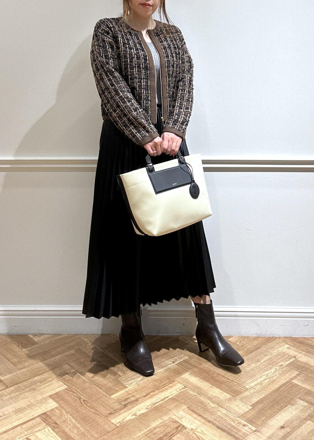 ブラウン系のブーツ、ブラック系のスカート、グレー系のニット/セーターを着用したレディースの秋コーディネートの2枚目の写真