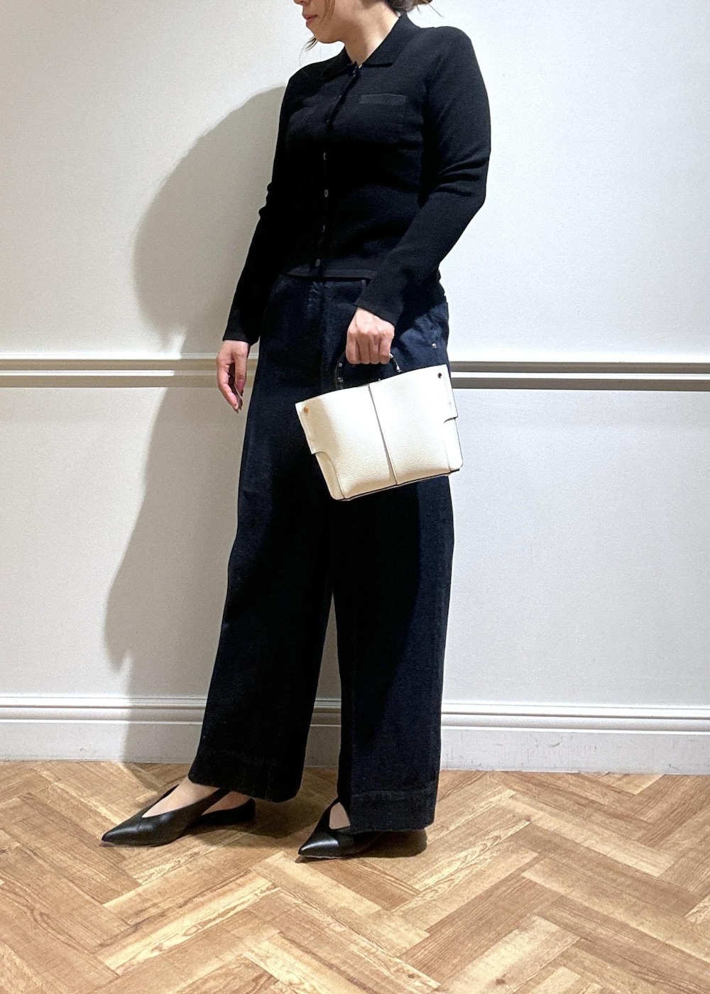 ホワイト系のハンドバッグ、ブルー系のデニムパンツ、ブラック系のカーディガン/ボレロを着用したレディースの春コーディネートの4枚目の写真