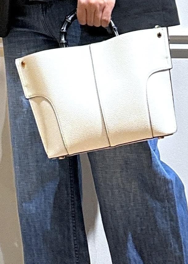 ブラック系のテーラードジャケット、ブルー系のデニムパンツ、ホワイト系のハンドバッグを着用したレディースの夏コーディネートの6枚目の写真