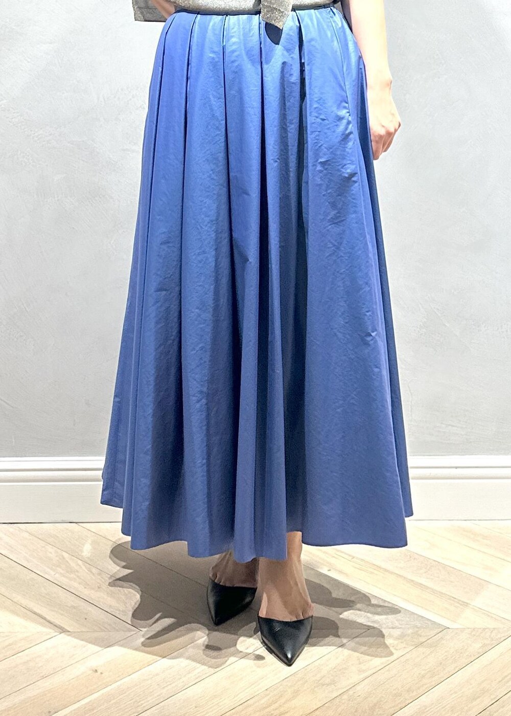 グレー系のハンドバッグ、ベージュ系のキャミソール、ブラウン系のニット/セーターを着用したレディースの夏コーディネートの4枚目の写真