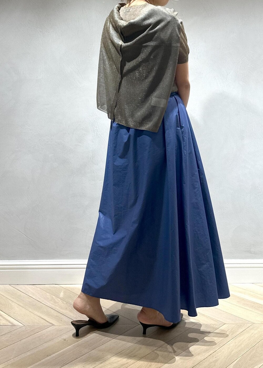 グレー系のハンドバッグ、ベージュ系のキャミソール、ブラウン系のニット/セーターを着用したレディースの夏コーディネートの3枚目の写真