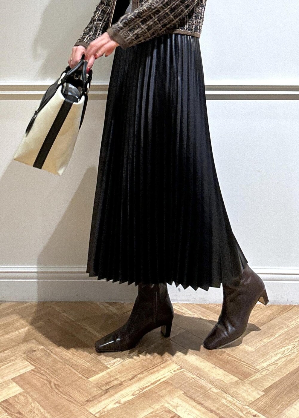 ブラウン系のブーツ、ブラック系のスカート、グレー系のニット/セーターを着用したレディースの秋コーディネートの6枚目の写真