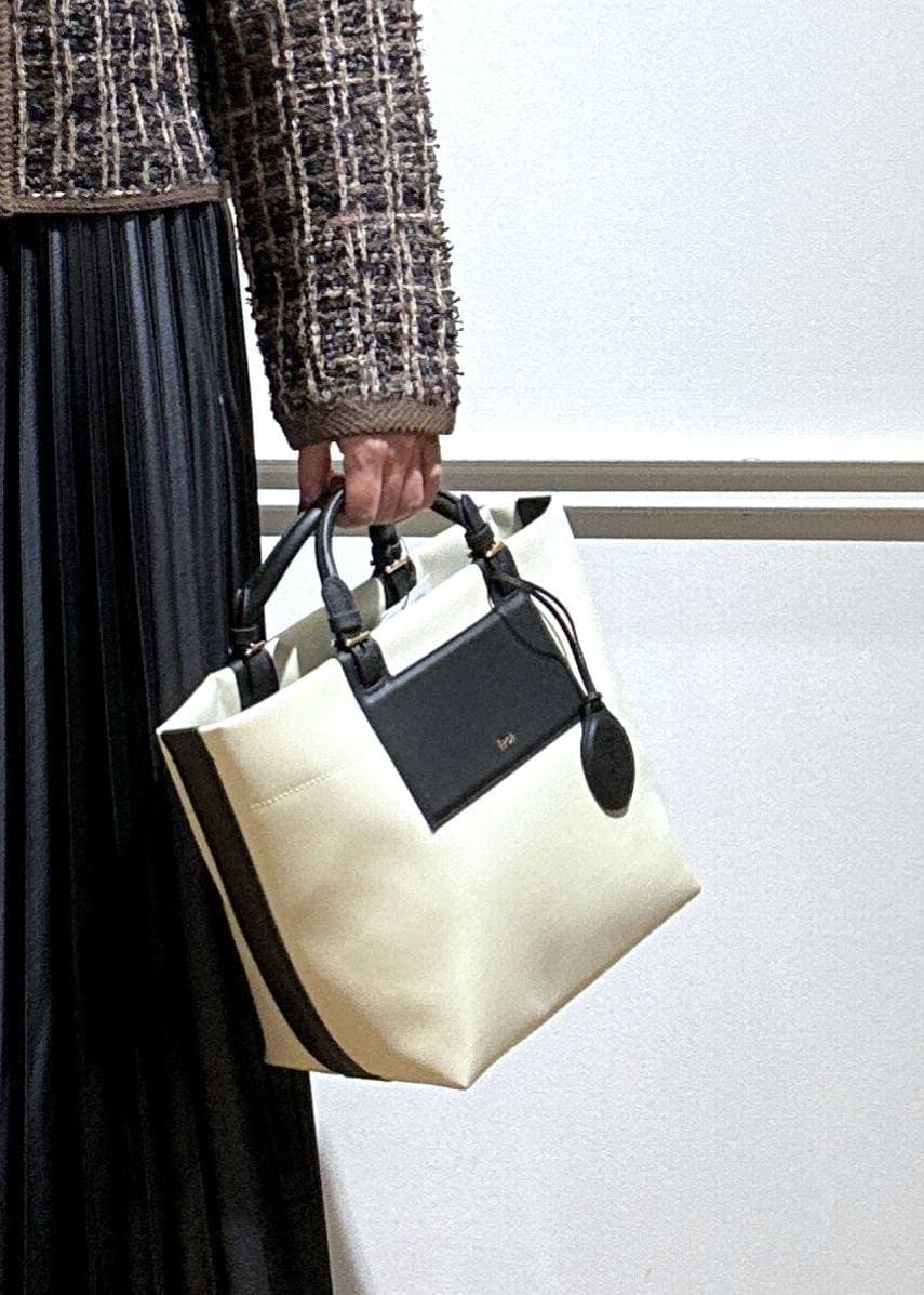 ブラウン系のブーツ、ブラック系のスカート、グレー系のニット/セーターを着用したレディースの秋コーディネートの7枚目の写真