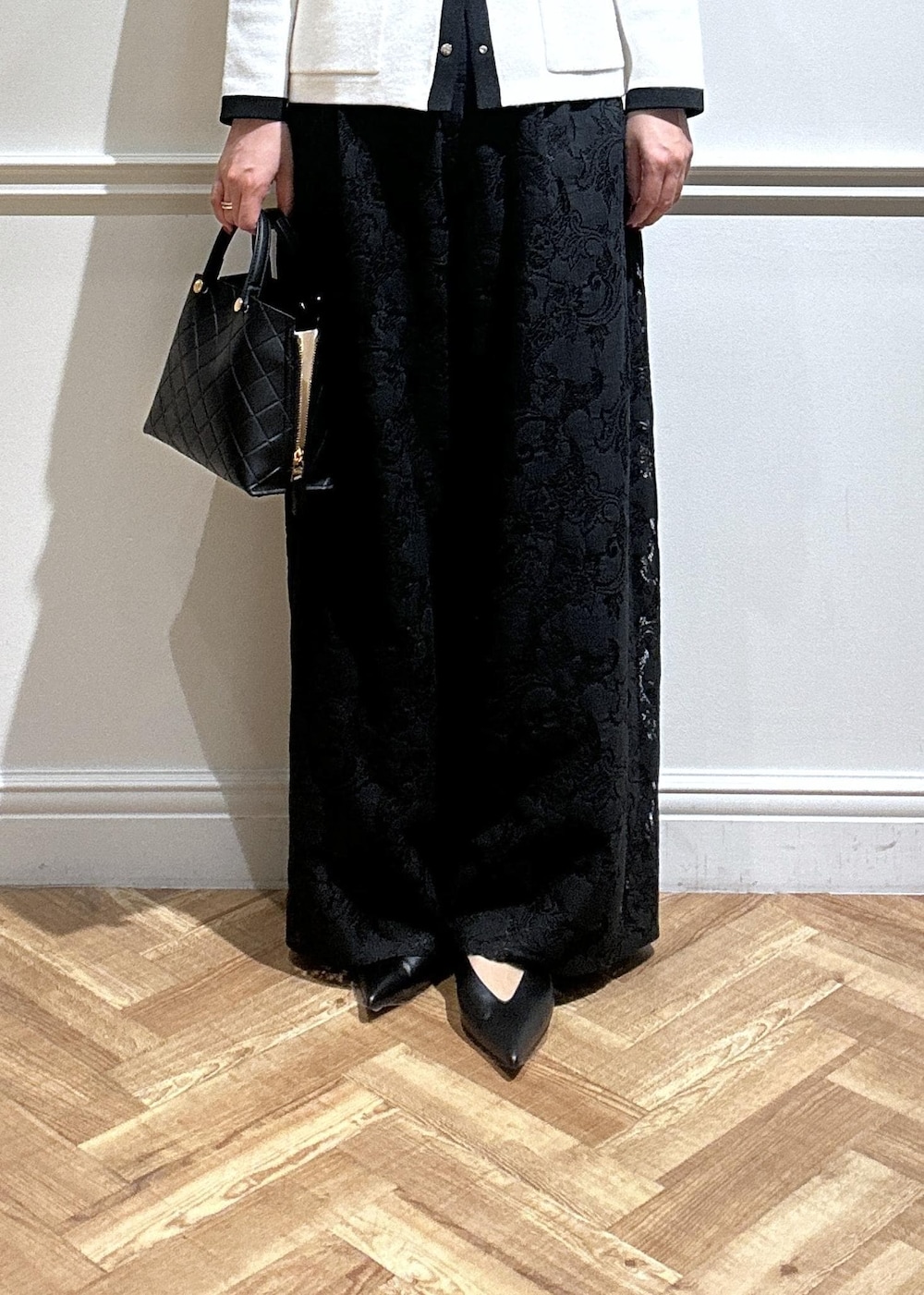 ブラック系のハンドバッグ、ブラック系のパンプス、ブラック系のその他パンツを着用したレディースの秋コーディネートの6枚目の写真