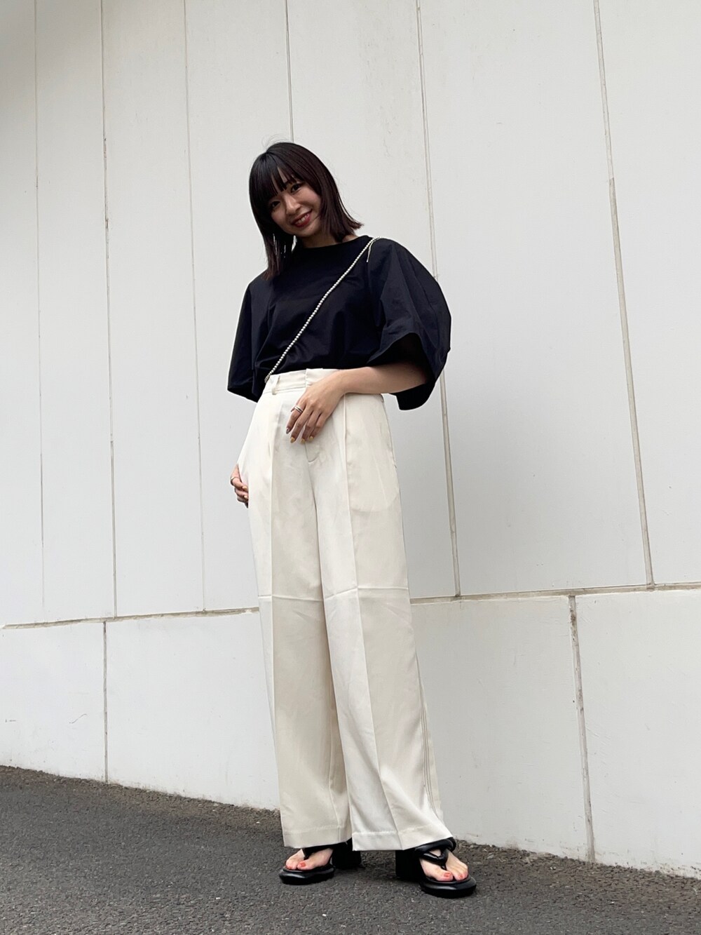 ブラック系のTシャツ/カットソー、ホワイト系のその他パンツ、ブラック系のサンダルを着用したレディースの夏コーディネートの2枚目の写真