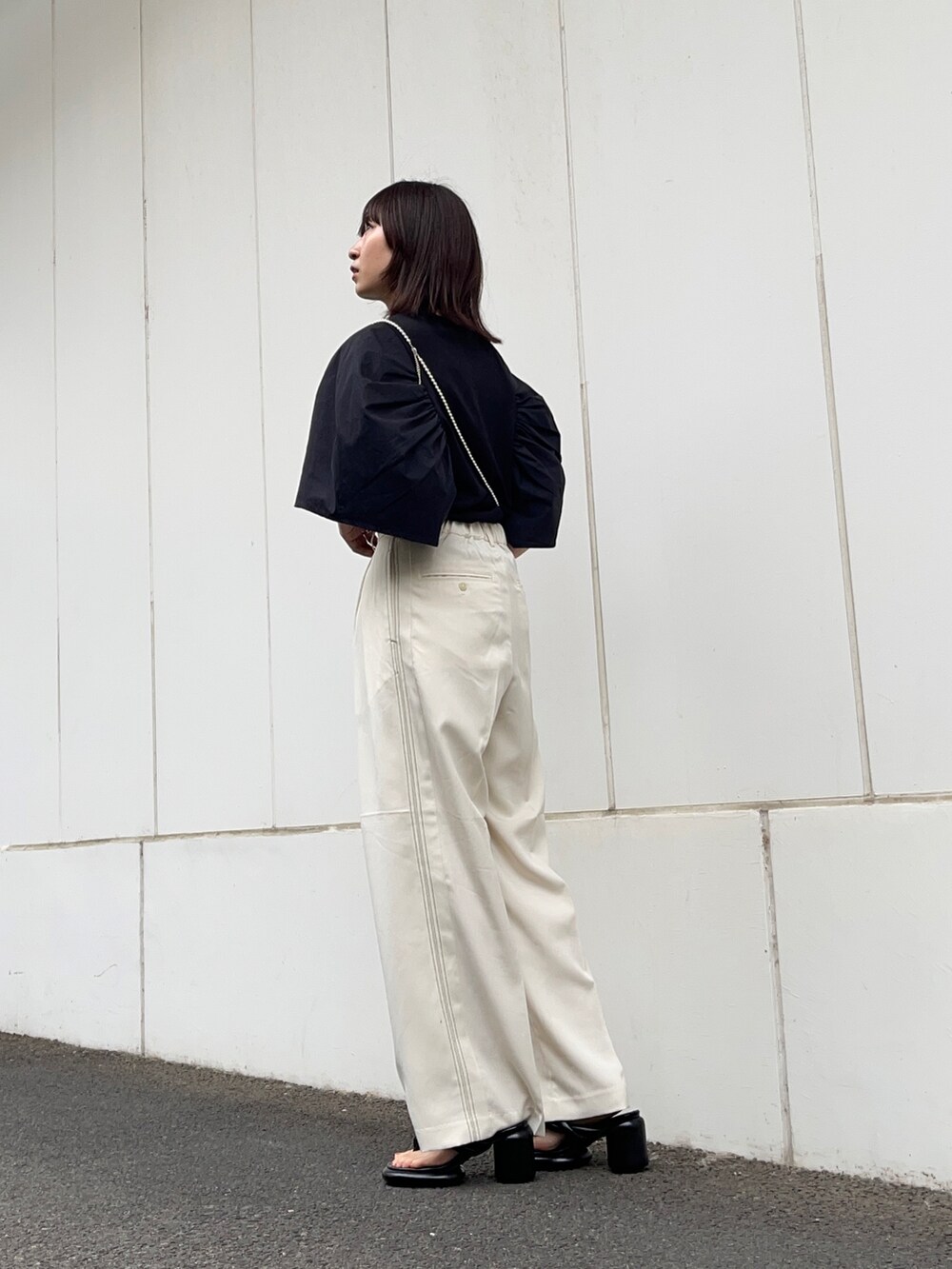 ブラック系のTシャツ/カットソー、ホワイト系のその他パンツ、ブラック系のサンダルを着用したレディースの夏コーディネートの3枚目の写真